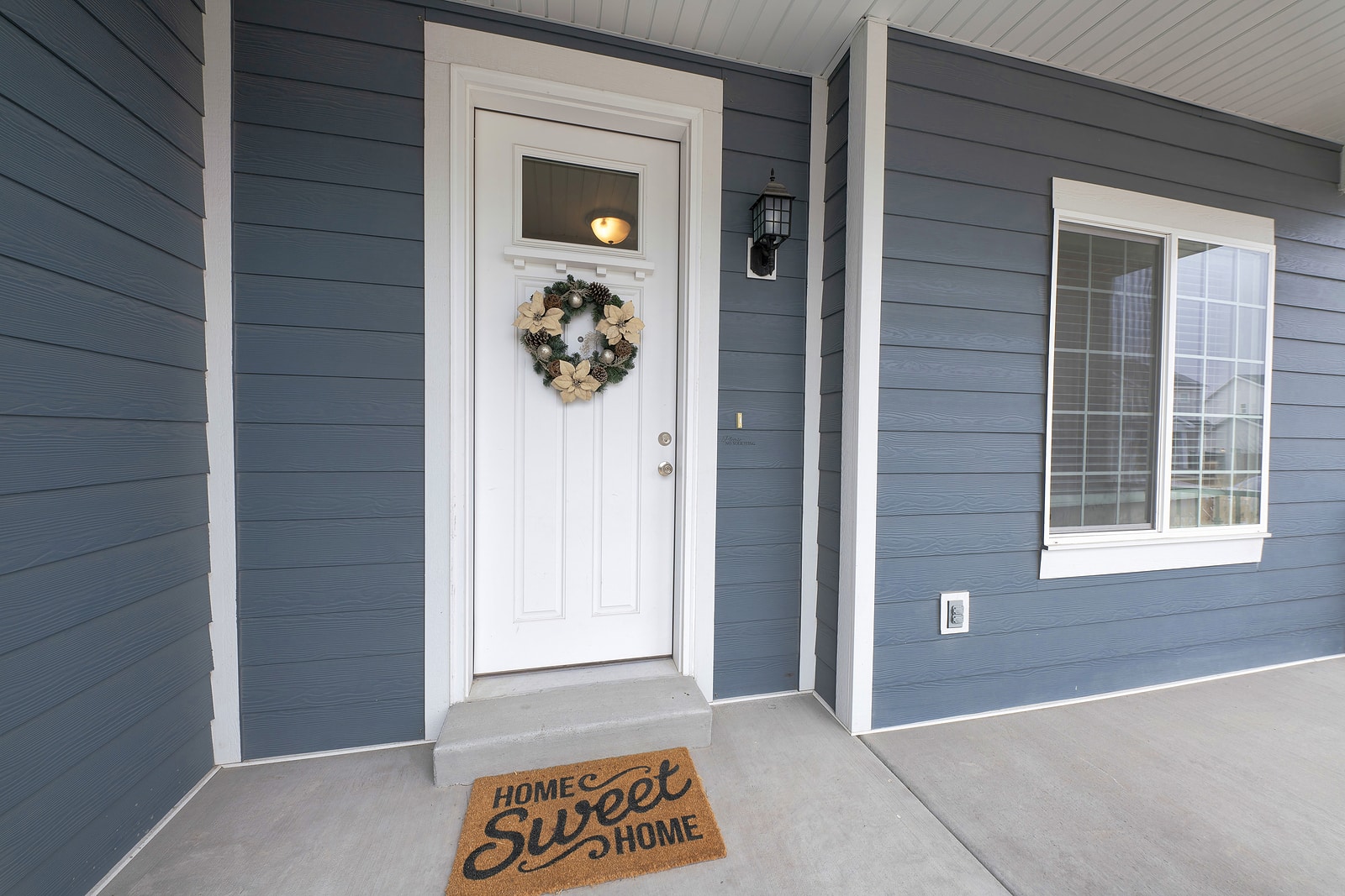 Front Entrance Exterior With Gray Vinyl Wood Siding And Concrete